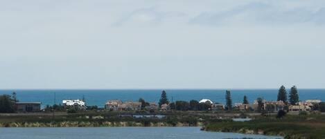 A coastal landscape with a body of water, houses, and vegetation.