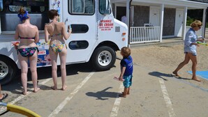 A beach scene with a white ice cream truck parked near a building with a porch. - Quaint & Cozy Downtown Chatham Home, Walk to Town and Beaches (Chatham)