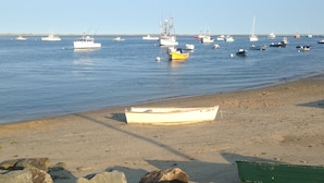 A beach with several boats anchored in calm waters. - Quaint & Cozy Downtown Chatham Home, Walk to Town and Beaches (Chatham)