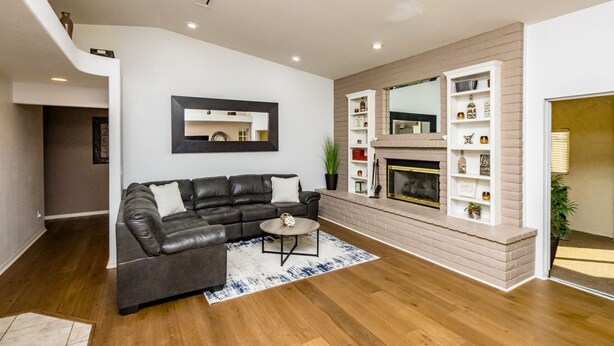 A modern living room with a leather sofa, a round coffee table, and a fireplace. - Spacious 3+3 w/ Pool & Game room, 5mins from Lake (Lake Havasu City)