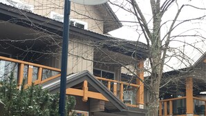 Ein Gebäude mit einer überdachten Außenfläche, verschneitem Gelände und einer Straßenlaterne.