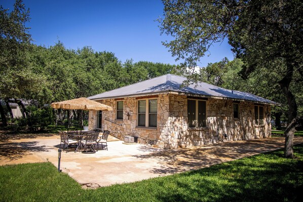 Set amidst lush greenery, this serene retreat offers a patio with outdoor furniture and a shaded area.