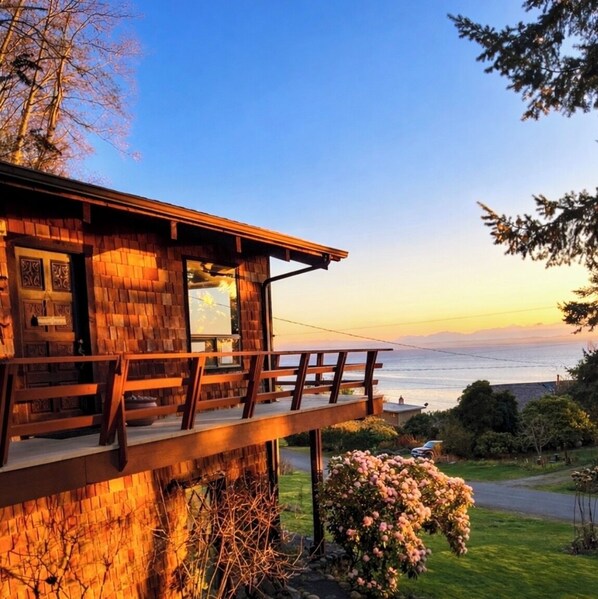 A wooden cabin with a balcony overlooking a body of water.