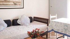 A room with a bed, a table with a vase of flowers, a chair, and a framed picture on the wall. - Mondomini - Charming cottage with view on the sea (Campofilone)