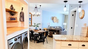 A modern kitchen with a central island, built-in appliances, and a dining area with a table and chairs.