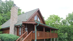 A log cabin with a stone chimney, a balcony, and a number 2219 sign. - The Cabin at Eagle Feather - Hot Tub, Pool Table! Seasonal Pool Mountain View (Sevierville)