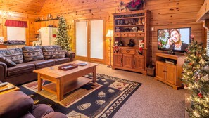 Cozy cabin-style room with a seating area, TV, and storage cabinet.