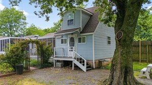 A two-story house with a porch, a small deck, and a tree in the foreground. - Pool Side Guest House On Lake Hudson Near Pryor (Adair)