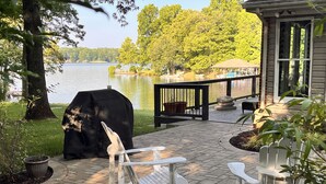 A patio with a grill, outdoor furniture, and a view of a lake. - Flat Lot, Views! Waterslide, Firepit, Kayaks, Pickleball, Pingpong, Tennis, WiFi (Moneta)