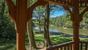 Un mirador de madera con vista a un lago rodeado de árboles.