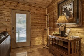 Enjoy a peaceful retreat with a door offering a view of the outside, a comfortable bench, and a small table with a lamp and picture.