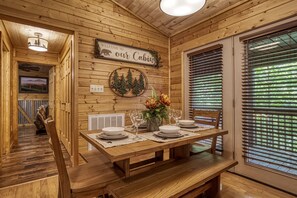 Enjoy a warm and inviting cabin-style room with a dining table set for a cozy meal.