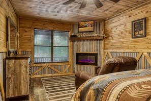 Cozy room with a fireplace, leather sofa, and large window with horizontal blinds.