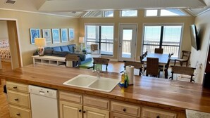 Una cocina amplia con encimera de madera, lavavajillas y un comedor con mesa y sillas.