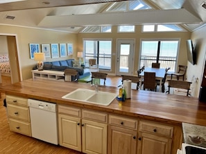 Una cocina amplia con encimera de madera, lavavajillas y un comedor con mesa y sillas.