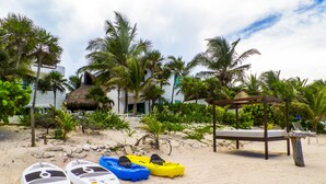 Una playa con kayaks, un pabellón y palmeras.