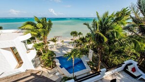 Un resort con piscina, zona de descanso y vista al océano.