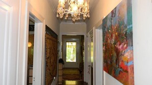 A hallway with a chandelier, a red carpet, and a large abstract painting on the wall. - Beautiful Cozy Bedroom In Great B&B  Historic Home ~ Close To The City Center  (Miami)