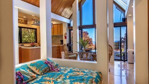Una habitación amplia con una cama grande, ventilador de techo y vistas al exterior.