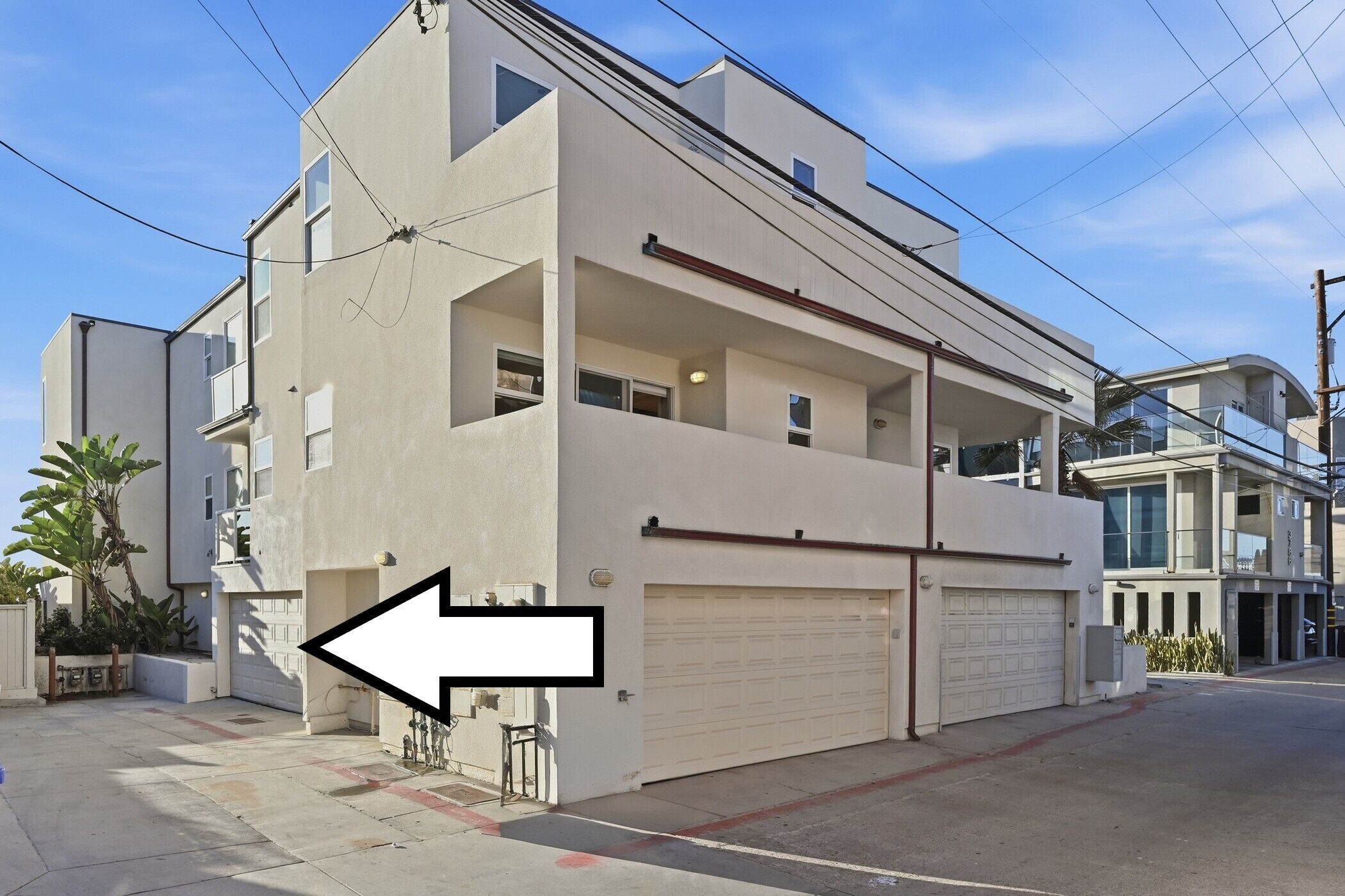 Ein modernes Wohnhaus mit zwei Etagen, einer sichtbaren Auffahrt und einer Garage.