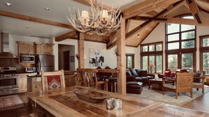 A spacious kitchen with wooden cabinets, a large island, and a chandelier.
