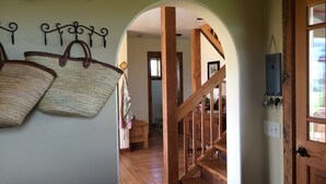A wooden staircase leading to a second floor, with a wall-mounted basket rack and a 'Don't Forget' sign. - Sweet and charming Victor home on three acres with Teton views! (Victor)