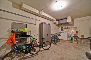 A garage with bicycles, a washing machine, and a utility cabinet.