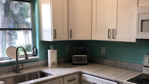 A kitchen with white cabinets, a stainless steel sink, a dishwasher, and a microwave. - STEPS TO BEACH & STEPS TO BAY & TO WATCH DOLPHINS! 3 MIN WALK TO RESTAURANTS (Englewood)