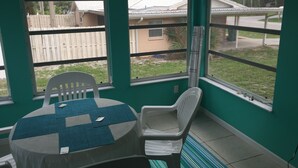A room with a table and chairs, large windows, and a view of a residential area. - STEPS TO BEACH & STEPS TO BAY & TO WATCH DOLPHINS! 3 MIN WALK TO RESTAURANTS (Englewood)
