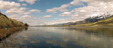 A calm lake with mountains in the background.