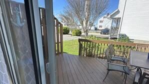 A deck with outdoor furniture, a view of the neighborhood, and a clear sky. - Beautiful updated condo w modern decor, overlooking Fenwick lighthouse from deck (Ocean City)