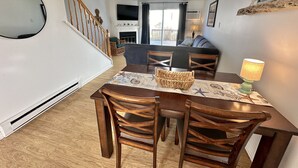 A dining area with a table, chairs, and a ceiling fan. - Beautiful updated condo w modern decor, overlooking Fenwick lighthouse from deck (Ocean City)