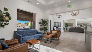 A modern lobby with a blue sofa, leather armchairs, and a coffee table.