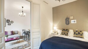 Une chambre à coucher avec un lit, des tables de chevet, une lampe et une horloge murale.