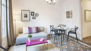 Un salon confortable avec un canapé, une table basse et un coin repas comprenant des chaises et une table.