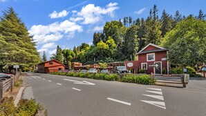 A red building with a 'One Way' sign, a parking lot, and a road with directional arrows.