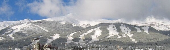 A mountainous landscape with snow-covered slopes and a clear sky.