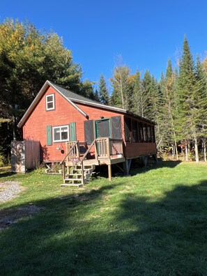A red cabin with a wooden deck and stairs leading to a porch. - Secluded / Private Maine Lake Retreat,
WIR SPRECHEN DEUTSCH , (Burnham)