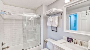 A modern bathroom with a glass-enclosed shower, white tiled walls, a large mirror, and a sink with a towel rack. - Gulf Place Cabanas 307 - Access to Pool (Santa Rosa Beach)