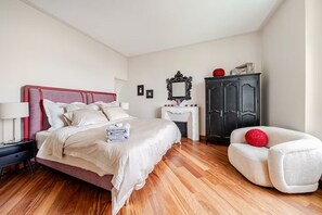 Une chambre à coucher comprenant un lit, une table de chevet, une commode et une chaise.