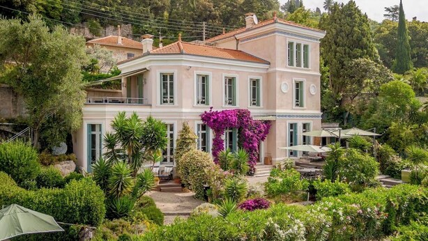 Un bâtiment à deux étages, doté d’un jardin à l’avant, avec un escalier menant à l’entrée.