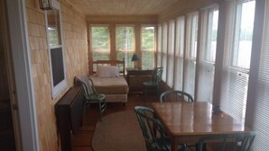 Ein gemütliches Zimmer mit einem Bett, einem Schreibtisch und einem Esstisch mit Stühlen.