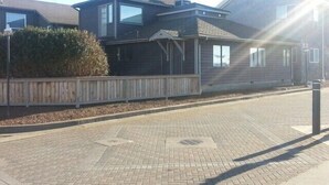 A two-story house with a porch, a chimney, and a fenced yard. - Three Bedroom / Two Bath Beach House In The Heart Of Nye Beach (Newport)