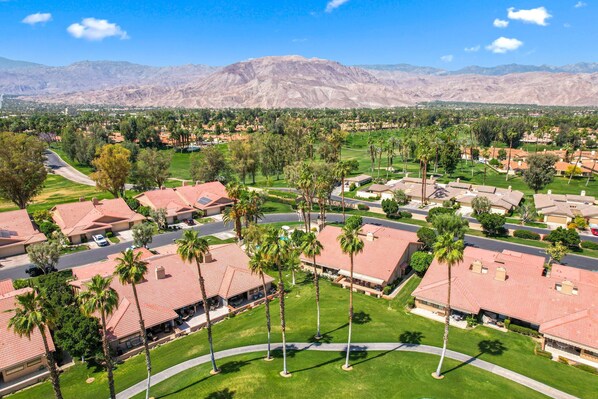 A residential area with houses featuring red-tiled roofs and palm trees. - Palm Desert - Chapparal (Palm Desert)