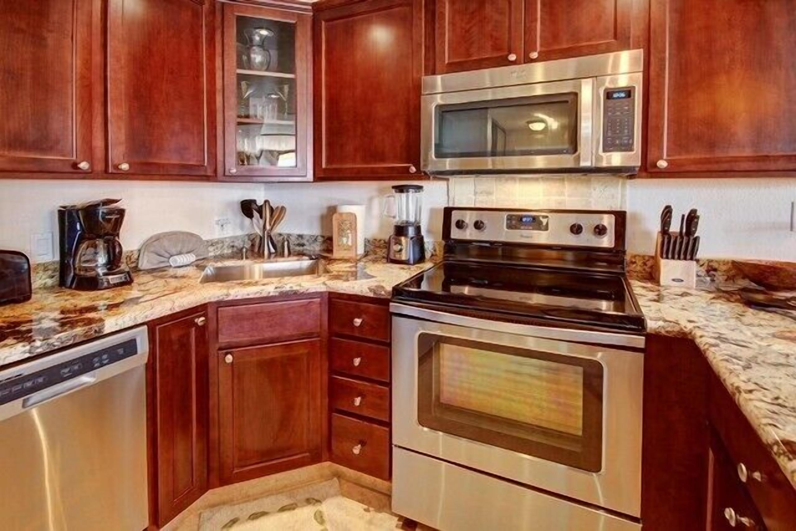 A kitchen with wooden cabinets, a stainless steel microwave, a stove, and a dishwasher.