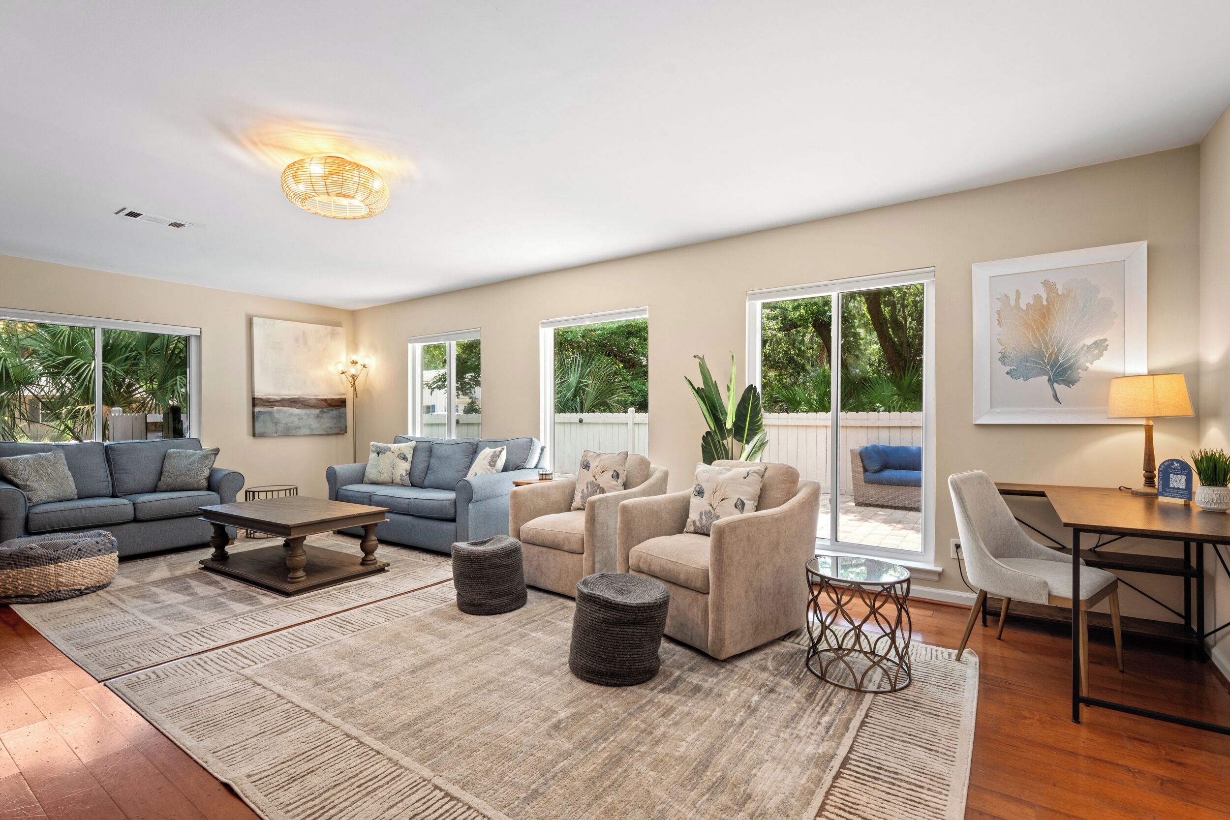 A spacious living room with a large window, a dining area, and a cozy seating arrangement.