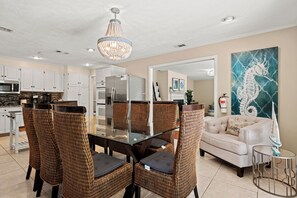 A modern kitchen with white cabinets, a stainless steel refrigerator, and a microwave.
