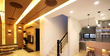 Una cocina moderna con estufa integrada, un comedor con mesa redonda y una escalera que sube a otro nivel.