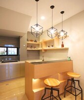 Una cocina moderna con una isla central, taburetes de madera e iluminación colgante.