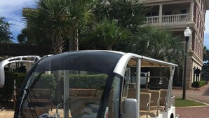 Un tram blanc de platja amb la frase “Beach Tram The Village” i “Homeowners & Guests” escrites al frontal.